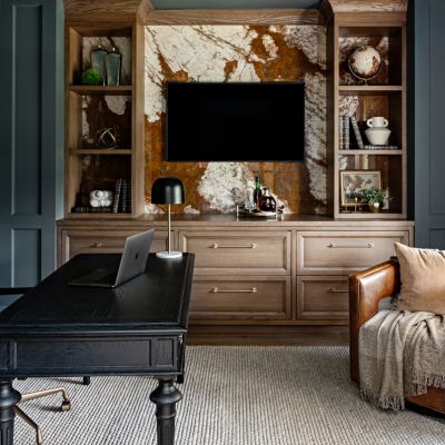 study with leather chair, throw blanket and tv feature wall